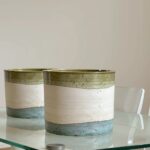 Two handmade ceramic indoor planters showing tricolor pottery glaze detail side by side