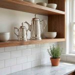 Moroccan silver coffee server duo displayed on modern open wooden shelving in contemporary kitchen with white subway tile backsplash