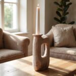 Textured square ceramic candle holder in terracotta with signature cutout design on wooden coffee table