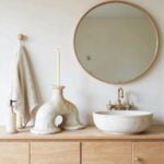 White ceramic candleholder with arch on bathroom vanity beside round mirror, handmade Tamegroute pottery decor