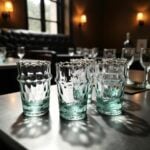 Set of aqua handblown diamond tea glasses on a wooden table in a traditional Moroccan dining room interior