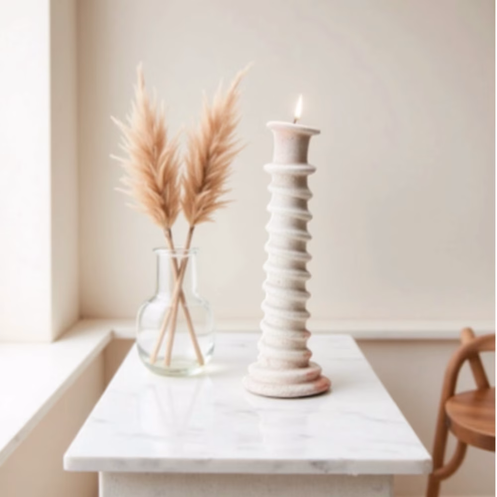 White ceramic candleholder on marble console