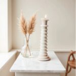 Cream colored ceramic candle holder tower with stacked rings on minimalist side table