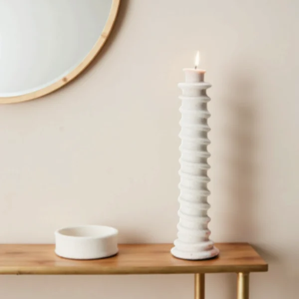 White spiral tall candle holder on wooden surface
