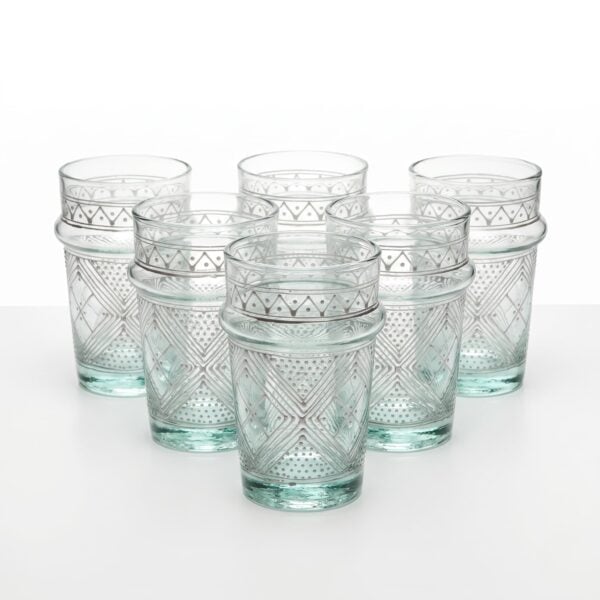 A matching set of six clear white geometric tea glasses with traditional Moroccan ridges and delicate white painted designs, arranged perfectly against a clean white studio background.