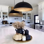Black dome pendant lights creating ambiance in contemporary white kitchen