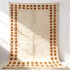 Close-up detail of handwoven border rug showing geometric pattern and fringe edges in cream and brown