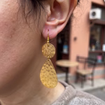 Close-up of hammered brass drop earrings