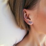 Close-up of sterling silver circle stud earrings on ear, showing secure post-back and polished finish