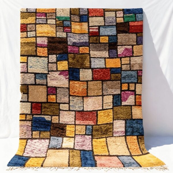 Patchwork color block rug handwoven with vibrant multicolor wool squares separated by black lines and fringe edges