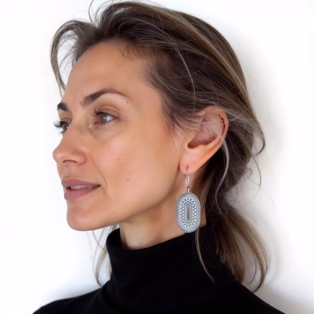 Model wearing silver oval drop earrings