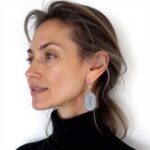 Silver Berber earrings worn showing detailed traditional sunburst pattern and oval drop design