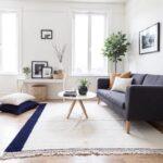 Modern wool rug in bright living room with navy diagonal stripe and Greek key pattern on cream base