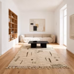 Moroccan Berber rug with traditional geometric patterns in minimalist living room featuring beige sectional sofa and wooden shelving unit