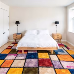 Moroccan patchwork color block rug in modern white bedroom setting