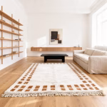 Neutral border rug with checkered design in modern minimalist living space with built-in seating