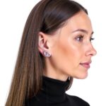 Woman wearing sterling silver circle stud earrings with Hermes-inspired oval design, side profile view