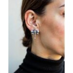 Sterling silver dragonfly earrings worn on ear showing detailed wing pattern and drop length