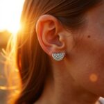 Close-up of sterling silver half circle earrings with concentric Berber stripes worn on ear lobe