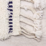 Traditional fringe detail of modern Moroccan navy and white rug