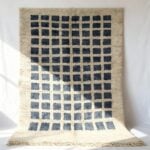 Modern wool rug with ombré blue gradient grid pattern on cream base with fringe detail