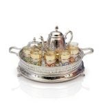 Luxurious large tea set with silver teapot and twelve glasses on ornate serving tray with handles