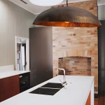 Copper dome pendant light above white kitchen island