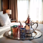 Elegant silver Moroccan tea set with vibrant colored glasses in sophisticated setting