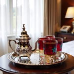 Elegant silver-plated small tea set with patriotic red glasses in bright home setting