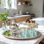Silver engraved beldi tea set with natural aqua glasses and intricate metalwork detail in a bright airy setting