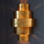 Illuminated Art Deco brass wall light showing light pattern