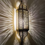 Illuminated Moroccan sconce light showing dramatic shadow patterns