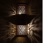 Illuminated Moroccan wall lamp showing dramatic shadow patterns