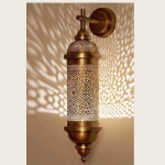 Illuminated Moroccan wall sconce showing intricate shadow patterns
