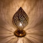 Illuminated brass table lamp creating intricate shadow patterns