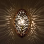 Illuminated oval wall light creating intricate shadow patterns
