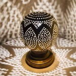 Illuminated round table lamp creating starlight shadow patterns