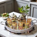 Engraved silver teapot and honeycomb glasses with mint in a large moroccan tea set on a carved tray