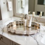 Hammered silver tray with pierced cutwork border organizing bottles on white marble vanity top