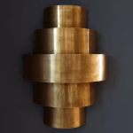 Tiered brass wall light dark background dramatic view