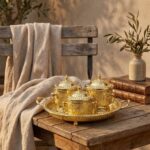 Moroccan brass sugar bowl set on rustic wooden table with engraved geometric motifs and curved handles