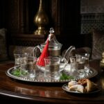 Silver engraved glass tea set with mint leaves on a dark wood table in a traditional interior