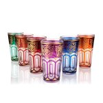Six colorful Moroccan tea glasses with gold arabesque patterns and arch designs in jewel tones on white background