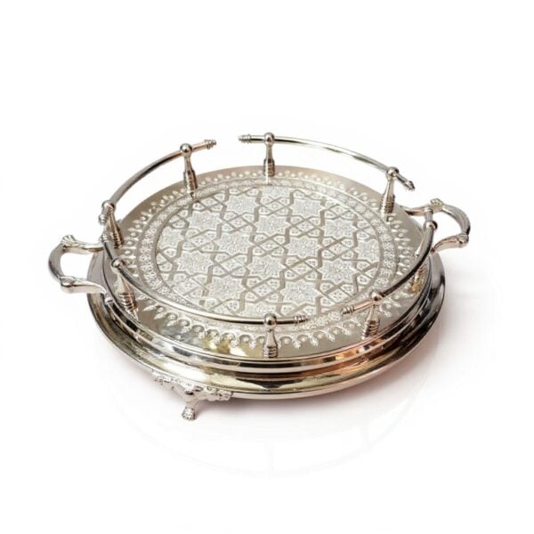 Hand-engraved silver large round tray with detailed geometric pattern and decorative feet viewed from an angle