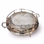 Hand-engraved silver large round tray with detailed geometric pattern and decorative feet viewed from an angle