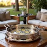 Silver tray with gold scrolled ornate handles on outdoor patio table
