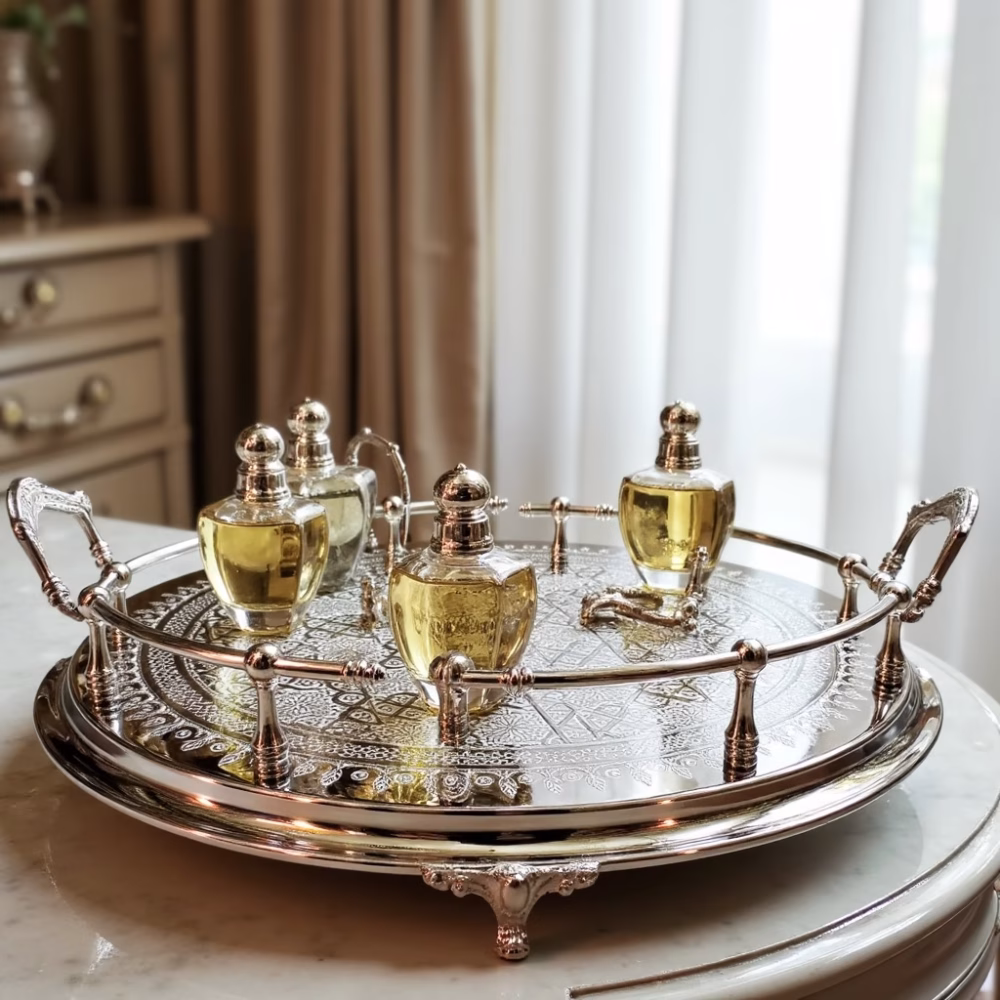 Silver hand-engraved large round tray displaying luxury perfume bottles on bedroom vanity