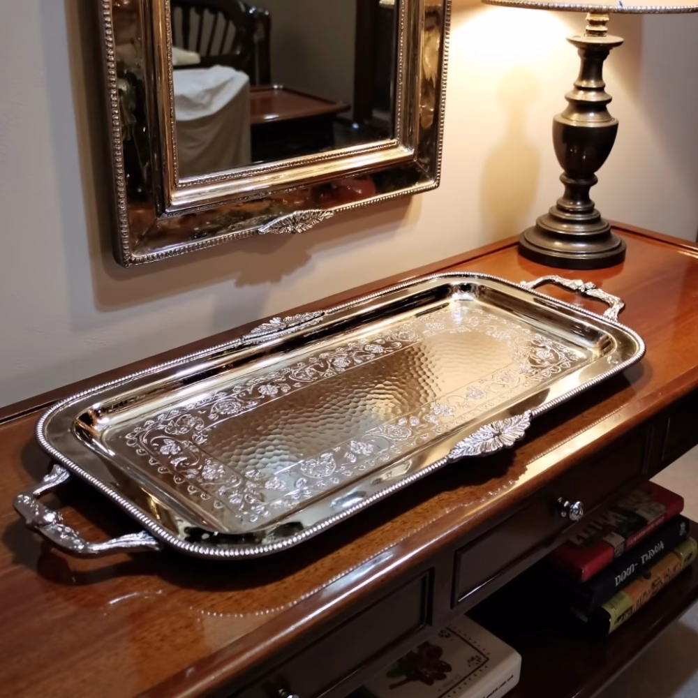 Decorative silver serving tray on wooden console table with matching mirror and lamp