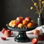 24cm tamegroute ceramic cake stand holding fresh fruit, showcasing teal-green glazed finish and raised pedestal