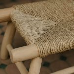 Close-up of handwoven straw bench figure-eight weave pattern in natural palm leaf fibers